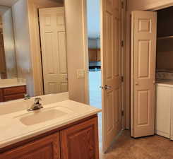 Bathroom featuring washer / clothes dryer, vanity, and tile patterned floors