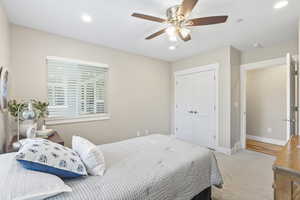 Carpeted bedroom featuring recessed lighting, a closet, and a ceiling fan