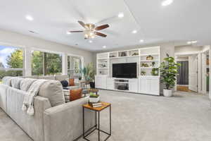 Basement living room featuring recessed lighting, a ceiling fan, and light colored carpet