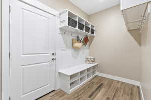Mudroom featuring light wood-type flooring and baseboards