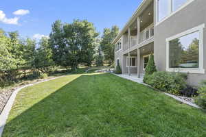 View of grassy yard featuring a patio