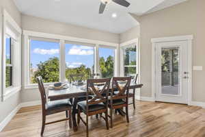 Dining area with light wood finished floors, plenty of natural light, vaulted ceiling, and a ceiling fan