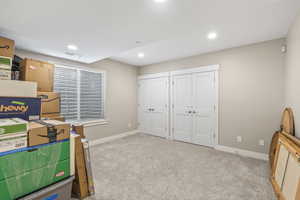 Carpeted bedroom with multiple closets and recessed lighting