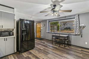 Kitchen featuring black appliances, wood finished floors, and a ceiling fan