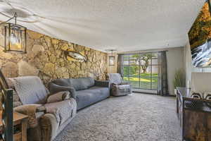 Living area with a textured ceiling and carpet