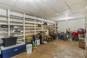 Below grade area featuring concrete block wall and a drop ceiling