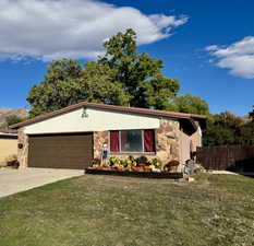 View of front of house featuring stone siding, concrete driveway, and a garage