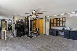 Office featuring ceiling fan, carpet, and built in desk