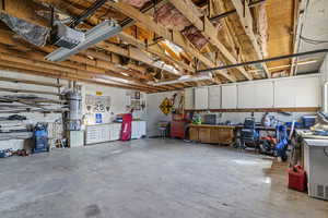 Garage with water heater, a workshop area, and a garage door opener
