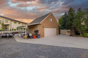 View of front of house with brick siding, a shingled roof, and driveway