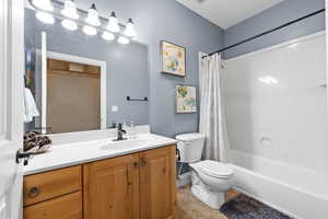 Full bath featuring vanity, shower / tub combo with curtain, and tile patterned floors