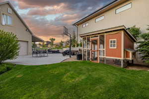 Back of property at dusk with exterior structure, an outbuilding, and a garage