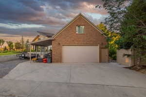 View of front facade featuring a garage, brick siding, and concrete driveway