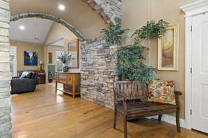 Corridor featuring vaulted ceiling, wood finished floors, and recessed lighting