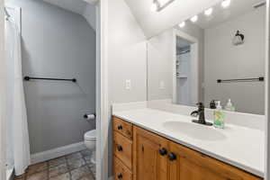 Full bathroom featuring vanity, stone flooring, and a shower with shower curtain