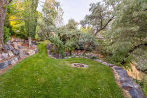 View of green lawn featuring a fire pit