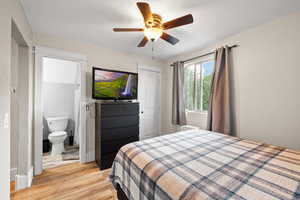 Bedroom featuring light wood-style floors, a textured ceiling, connected bathroom, and ceiling fan