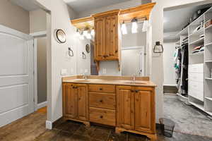 Full bath with double vanity and a walk in closet
