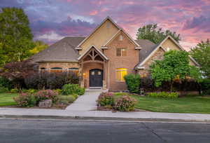 Traditional-style house with a front yard, brick siding, and french doors