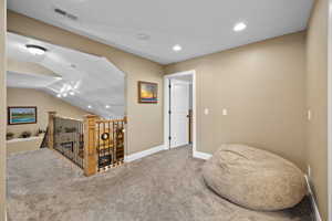 Hallway featuring carpet floors, recessed lighting, and lofted ceiling