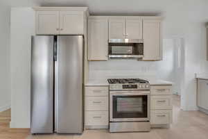Open Remodeled Kitchen featuring all new custom cabinetry, new Quartz stone countertops and large tile floors, stainless appliances, 5 burner gas range, stainless steel door top control dishwasher, refrigerator with freezer and microwave.