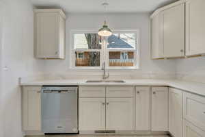 Open Updated Kitchen featuring all new custom kitchen cabinetry, Quartz stone counters, 5 burner gas range, refrigerator with freezer, stainless steel dishwasher and microwave, new tile flooring and decorative light fixtures.