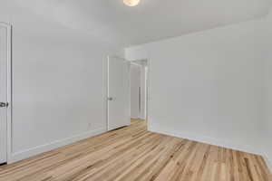 Second bedroom featuring single hung double pane window, hard wood finished floors and baseboards with walk-in closet.