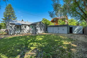 Private Backyard of home featuring shady yard, a  workshop with metal roof and a storage unit.