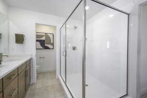Full bathroom with vanity, a stall shower, and tile patterned floors