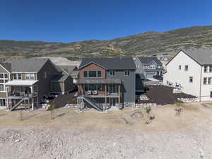 Back of house with a residential view, stairs, and a mountain view