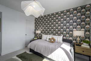 Bedroom with carpet floors and wallpapered walls