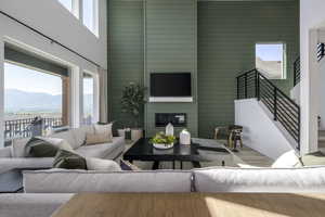 Living area featuring a high ceiling, wood finished floors, stairway, a mountain view, and a fireplace