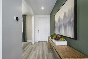 Hallway with light wood-style floors and baseboards