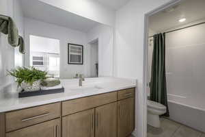 Full bath with vanity, tile patterned floors, and shower / tub combo with curtain