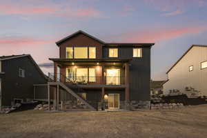 Rear view of house featuring stairway and stone siding