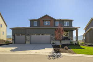 View of front of house featuring driveway, a standing seam roof, a porch, a metal roof, and a garage