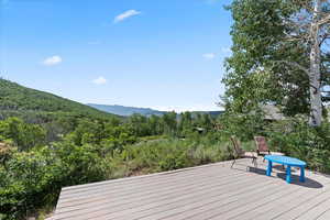 Deck with a mountain view and a forest view