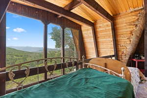Bedroom featuring a mountain view, wood walls, and wood ceiling