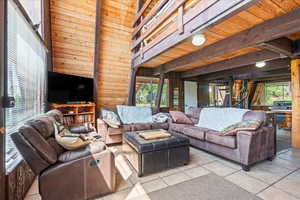 Tiled living area featuring wood walls and healthy amount of natural light