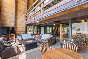 Living area with wood walls, tile patterned floors, plenty of natural light, and wood ceiling