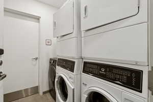Washroom featuring washing machine and clothes dryer and light tile patterned floors