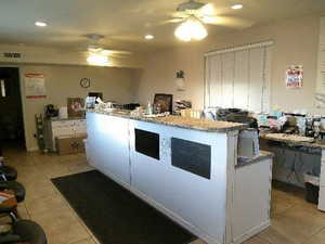 Kitchen with ceiling fan, light tile patterned floors, recessed lighting, and a center island