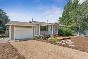 Single story home with dirt driveway and a garage