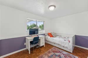 Bedroom featuring baseboards and a textured ceiling
