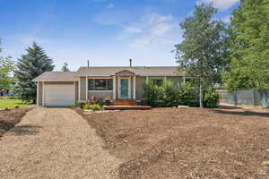 Ranch-style house with a garage, driveway, and roof with shingles
