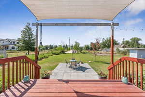Deck with a patio, a yard, and outdoor dining space