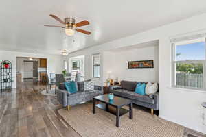 Living room featuring dark wood-type flooring and a ceiling fan