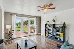 Living room with a ceiling fan and wood finished floors