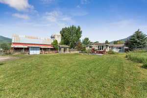 View of yard with a storage unit and a deck with mountain view