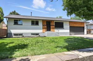 View of front of home featuring an attached garage, concrete driveway, and brick siding